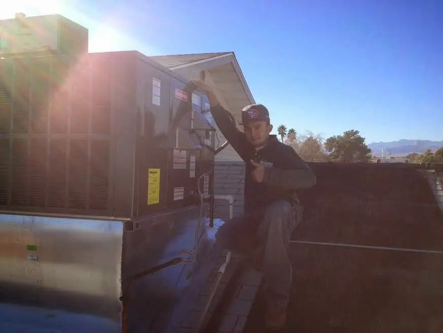 HVAC technician performing Boiler Repair on a rooftop unit in California